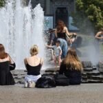 People cooling off in a fountain during a summer heatwave in Berlin, Germany.