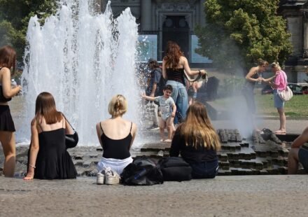 People cooling off in a fountain during a summer heatwave in Berlin, Germany.