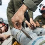 US Marines loading an AIM-120C AMRAAM air-to-air missile onto an F-35B fighter aircraft in Japan.
