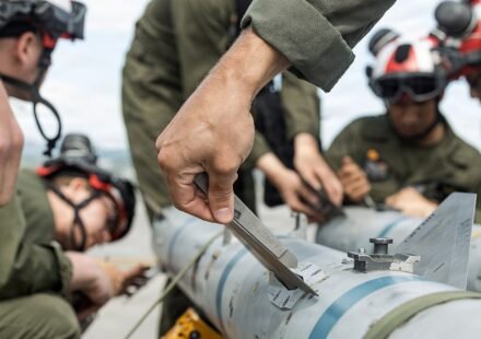 US Marines loading an AIM-120C AMRAAM air-to-air missile onto an F-35B fighter aircraft in Japan.